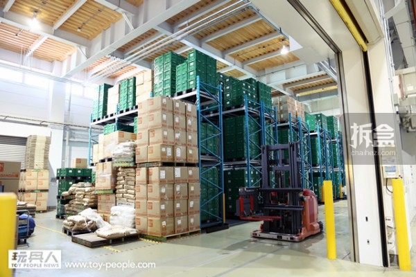 工厂的旁边就是仓库，全部7,500 个绿色的收纳箱，藉由全自动化机器人搬运，并利用条码来管理。收纳箱为绿色配色，表明为量产型的产品。